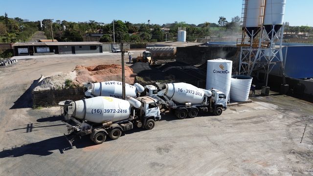 Caminhões betoneira da CONCRECIA carregando sob os silos da central dosadora